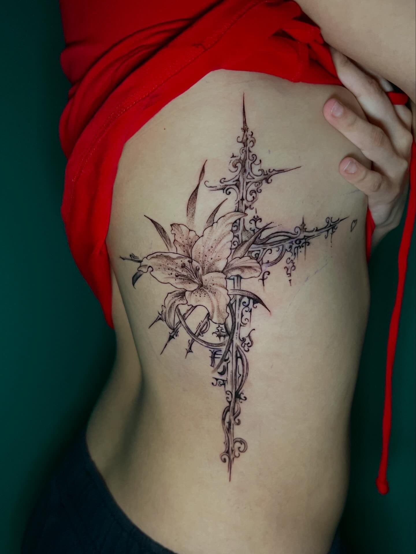 Fine line cross tattoo with lilies and thorns on the back by Alison at Inked City Tattoos in Trenton, NJ