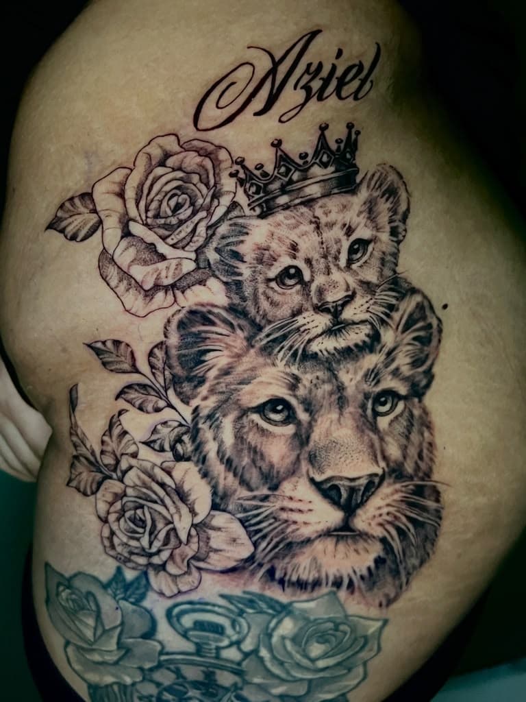 Black and grey lion and cub tattoo with crown, roses, and name script by Alison at Inked City Tattoos in Trenton, NJ