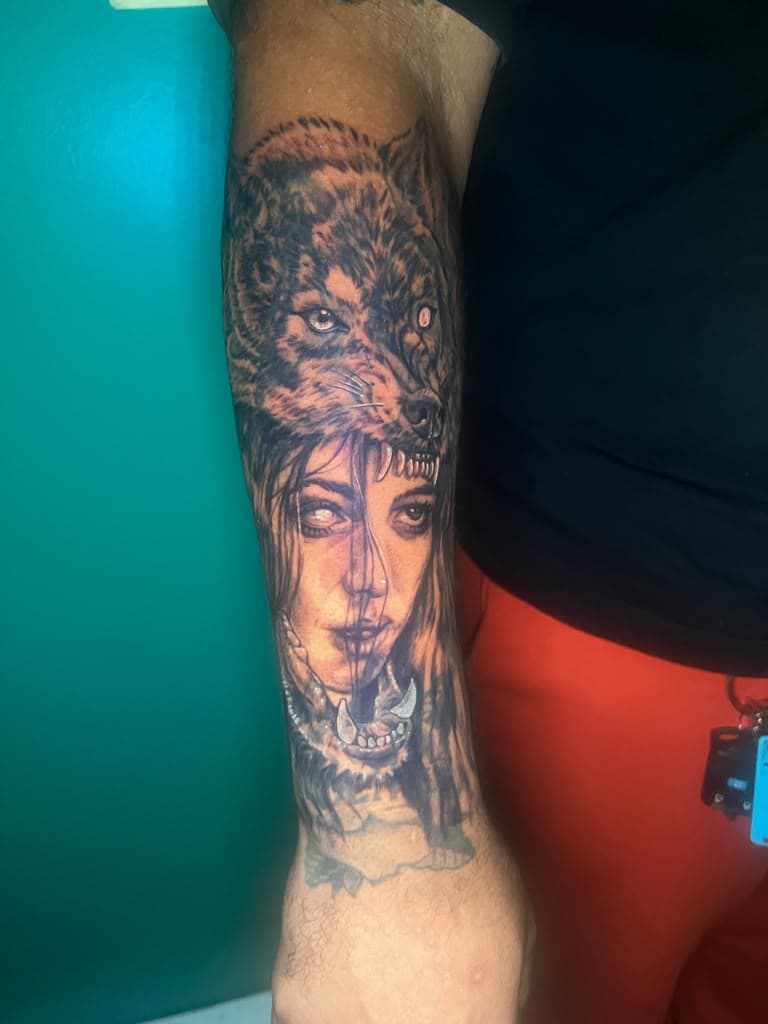 Black and grey tattoo of a woman wearing a wolf headdress on forearm by Alison at Inked City Tattoos in Trenton, NJ