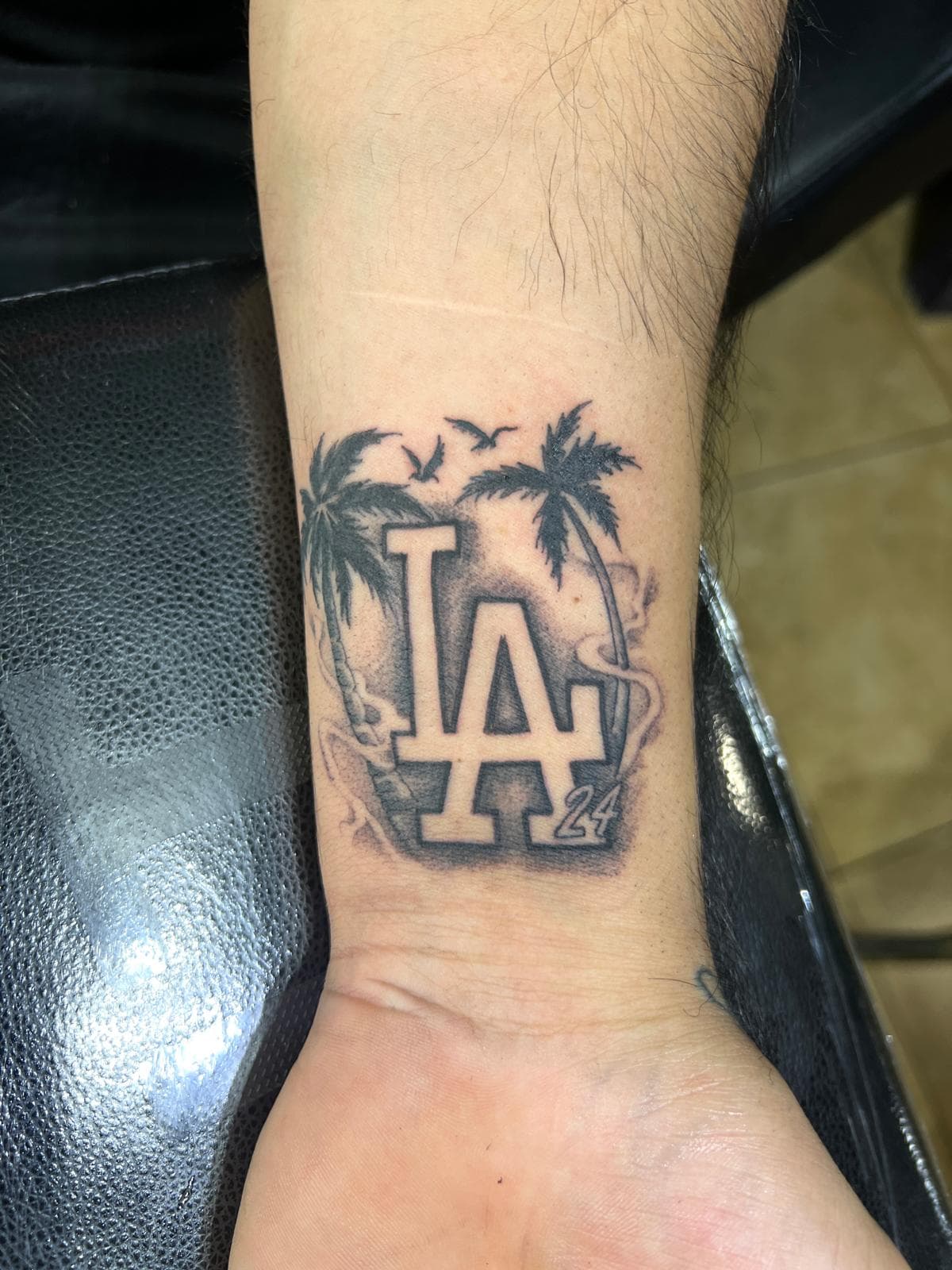 Black and grey LA logo tattoo with palm trees on forearm by Alison at Inked City Tattoos in Trenton, NJ